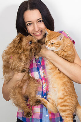 Woman holding a cat and a dog