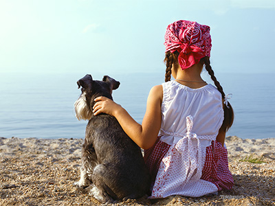 girl and dog at the beach